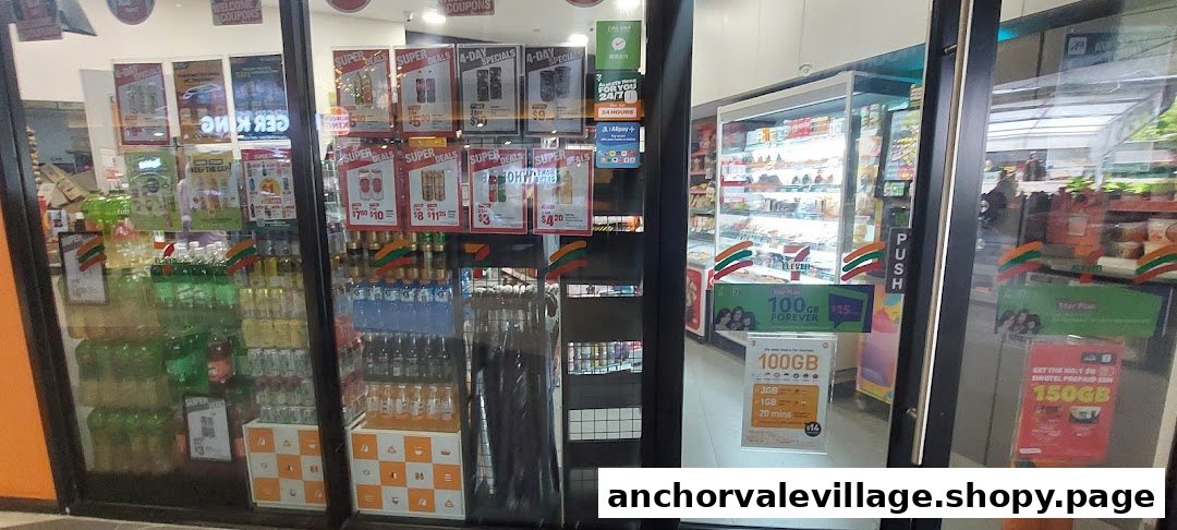 The storefront of a 7-Eleven convenience store, showcasing various products and promotional signs.