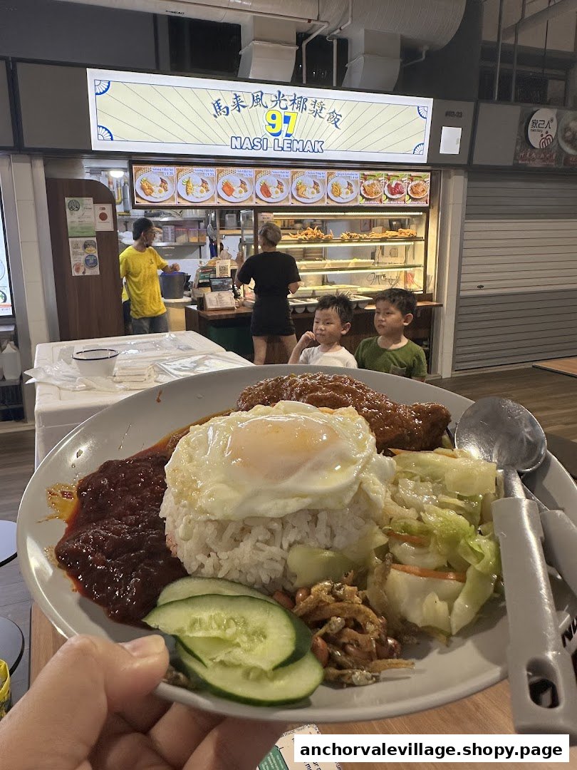 A delicious plate of Nasi Lemak in the foreground with the 97 Nasi Lemak stall visible in the background.