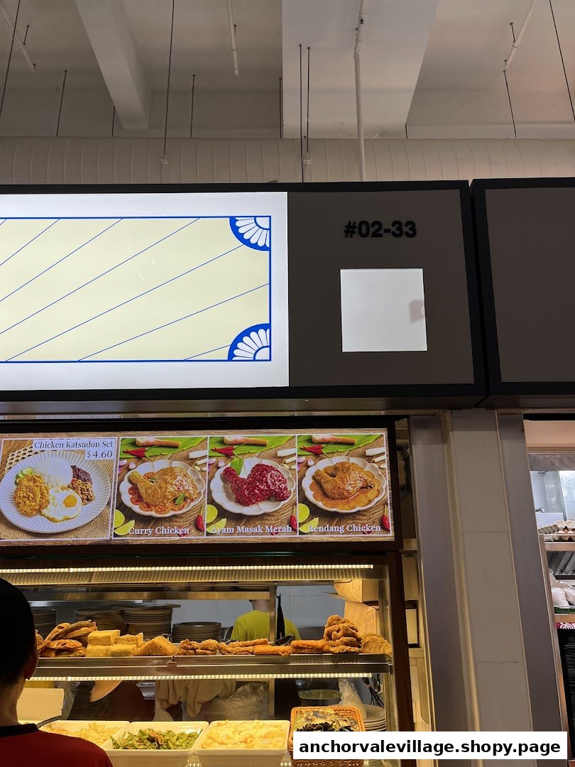A display board showcasing various chicken dishes and a food counter at a Nasi Lemak stall.