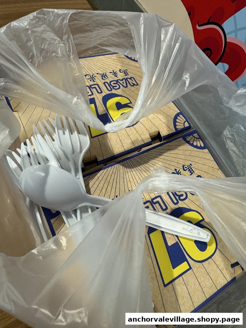 Takeaway boxes of Nasi Lemak with plastic cutlery inside a clear bag.