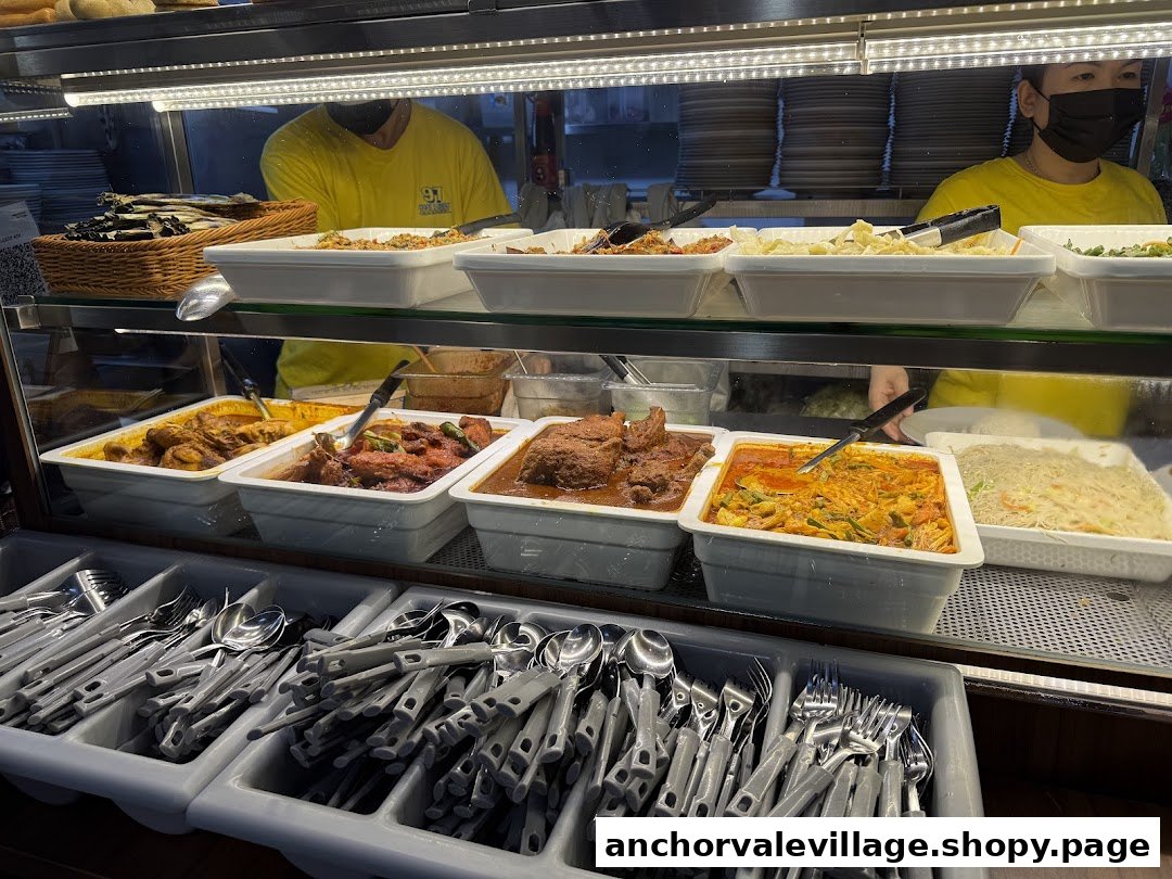 A vibrant display of various hot dishes and cutlery at 97 Nasi Lemak, with staff in yellow shirts.