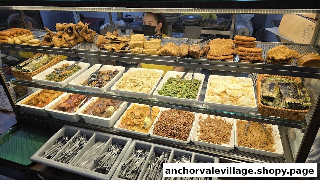 A vibrant display counter showcasing a wide variety of freshly prepared dishes and fried items at a food stall.