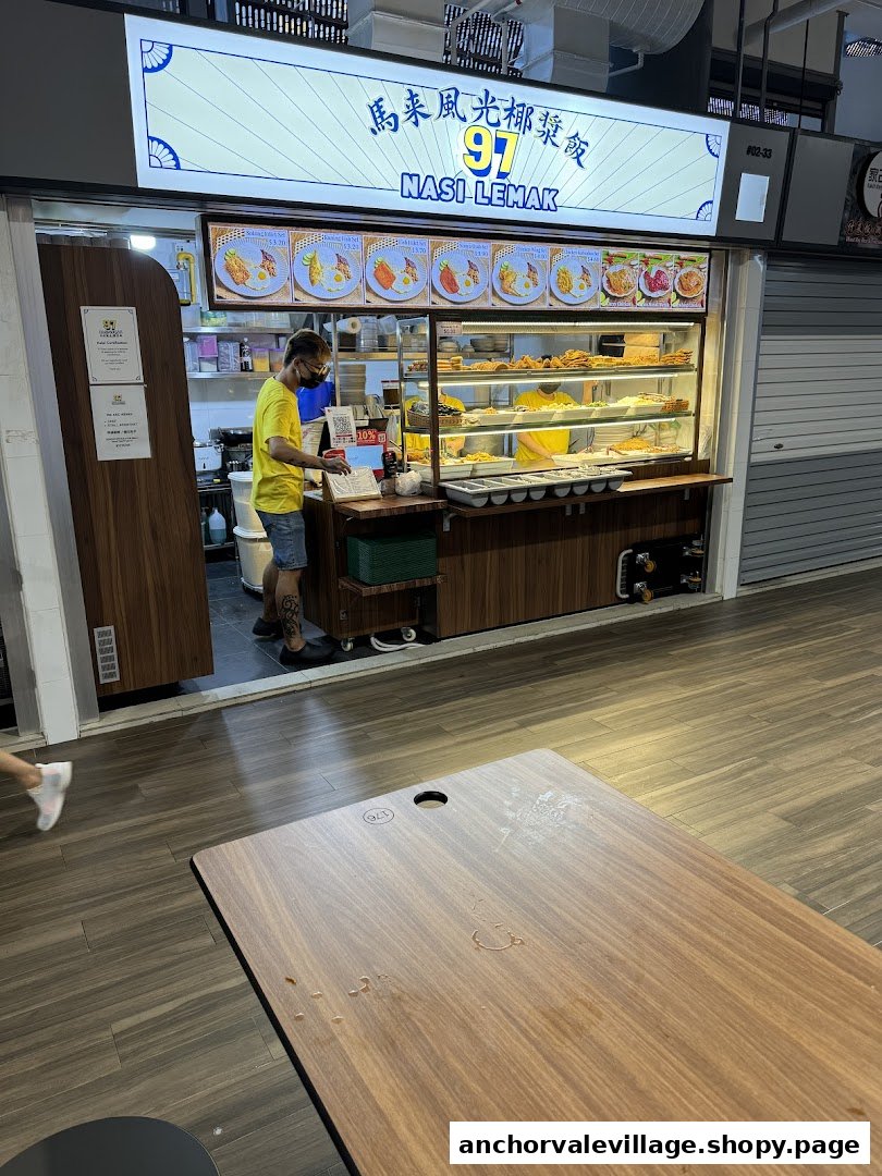 A staff member at the counter of 97 Nasi Lemak stall, showcasing its offerings.