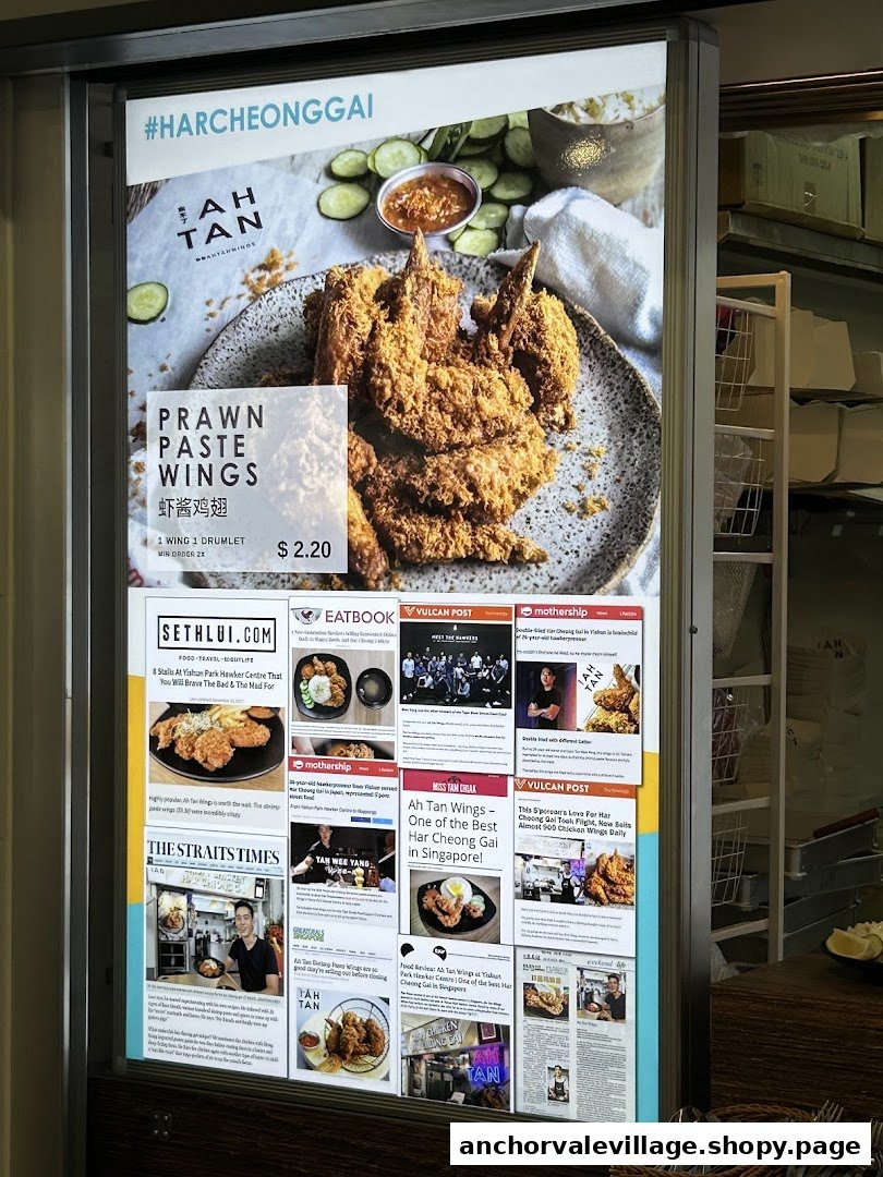 A promotional display featuring Ah Tan Wings' Prawn Paste Wings with price and media reviews.