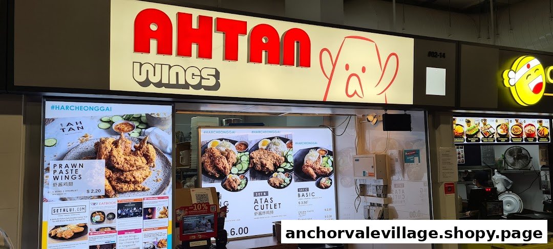 A food stall named Ah Tan Wings with its illuminated signage, counter, and menu displays.