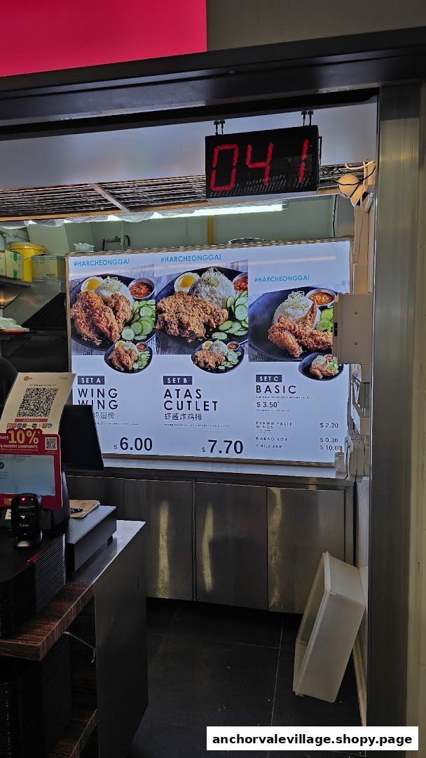 A digital menu board displaying various fried chicken sets and add-ons with prices at Ah Tan Wings.