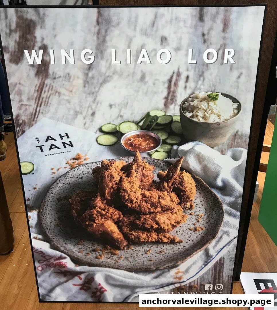A promotional poster featuring crispy fried chicken wings, rice, and cucumber slices from Ah Tan Wings.