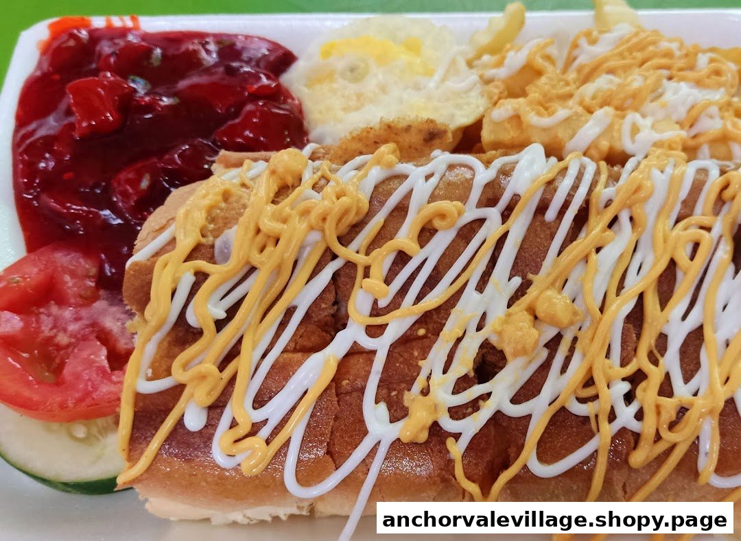 A close-up of a hot dog with cheese and mayonnaise, served with fries, a fried egg, and a side dish.