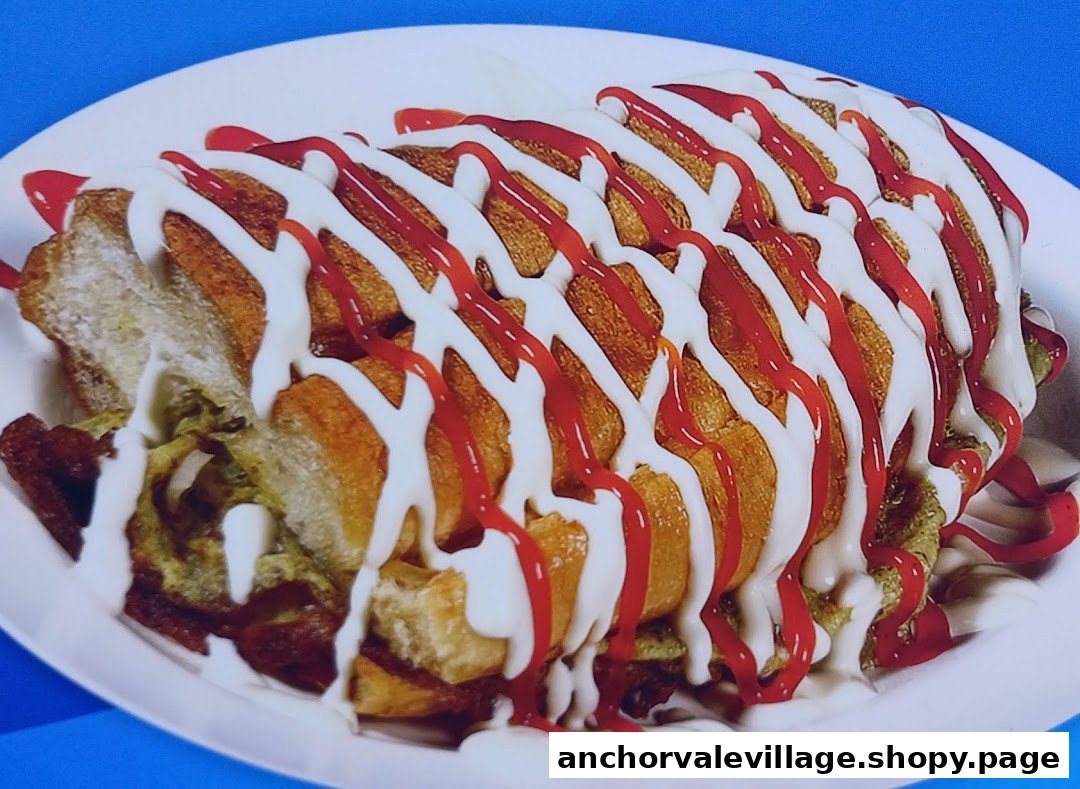 A close-up of a savory sandwich or roll generously topped with white and red sauces.