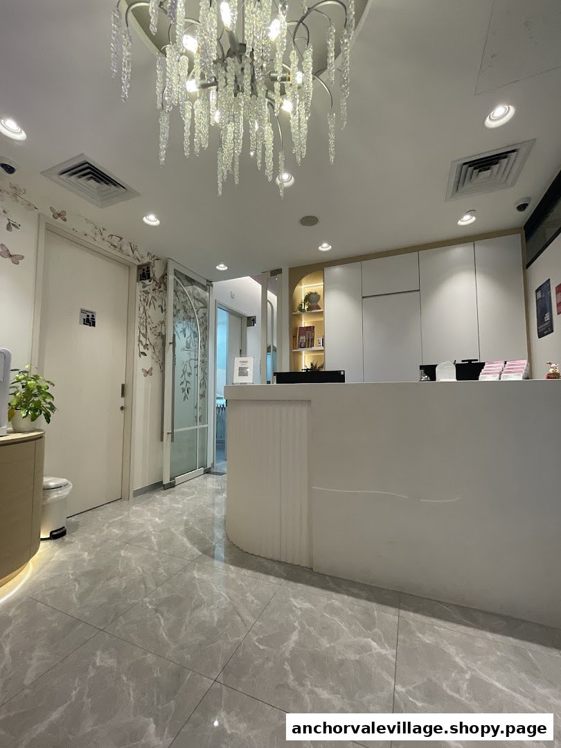 Interior view of a modern dental clinic reception area with a white counter and elegant chandelier.