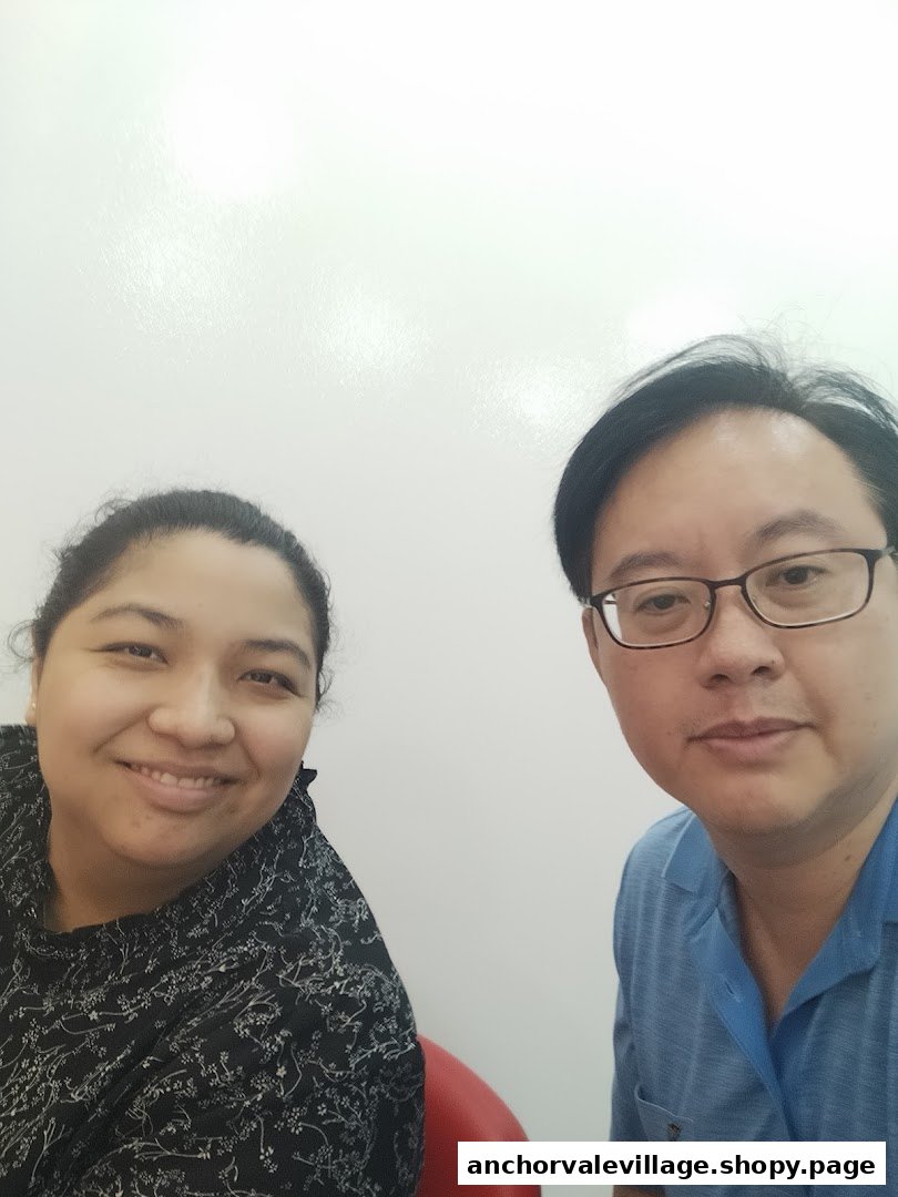 Two smiling individuals, likely staff or patient and staff, in a clean, bright setting.