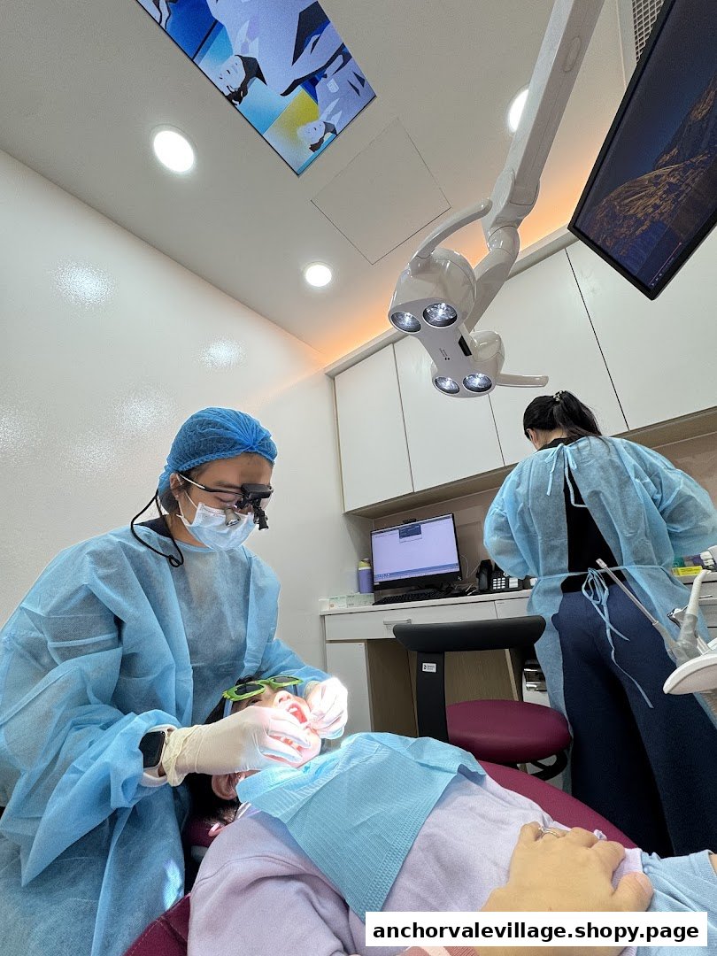 A dentist and assistant performing a procedure on a patient in a bright, modern dental clinic.