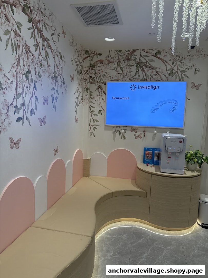 A modern and inviting dental clinic waiting area with floral wallpaper, comfortable seating, and an Invisalign display.
