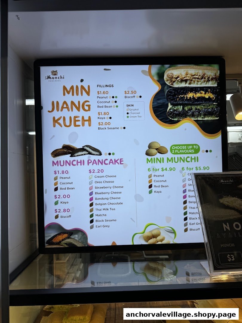 A digital menu board displaying various pancake types, fillings, and prices from Munchi Pancakes.