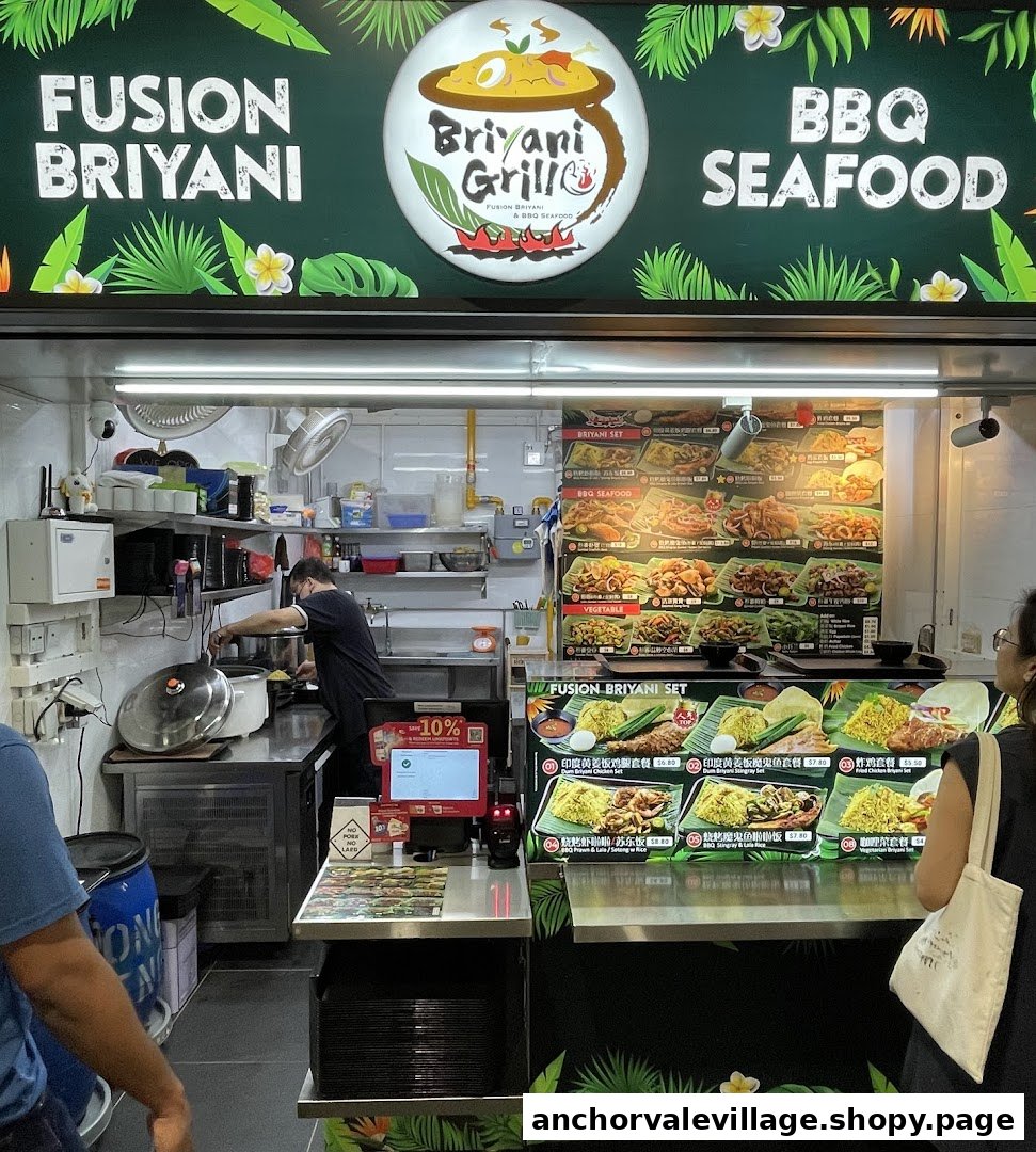 A hawker stall named Briyani Grill, specializing in Fusion Briyani and BBQ Seafood, with a staff member preparing food.