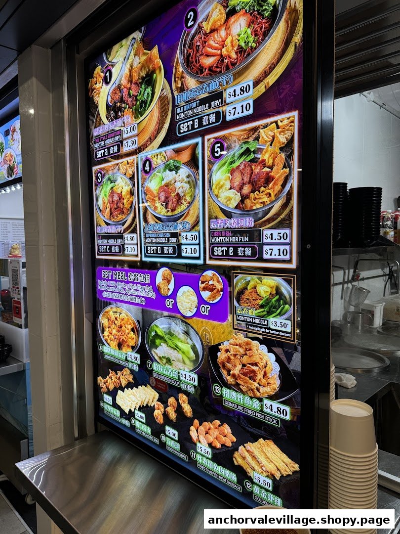 A vibrant digital menu board displaying various noodle dishes, wontons, and fried snacks with prices.