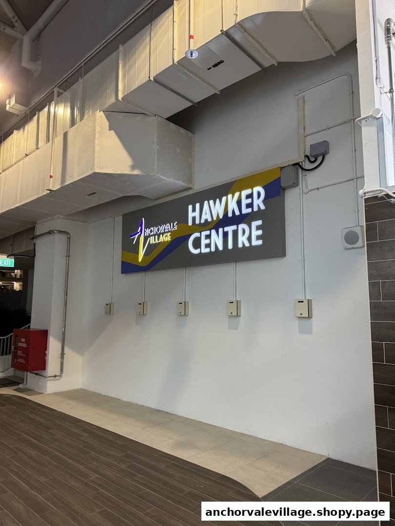 The illuminated entrance sign for Anchorvale Village Hawker Centre, showcasing its name.