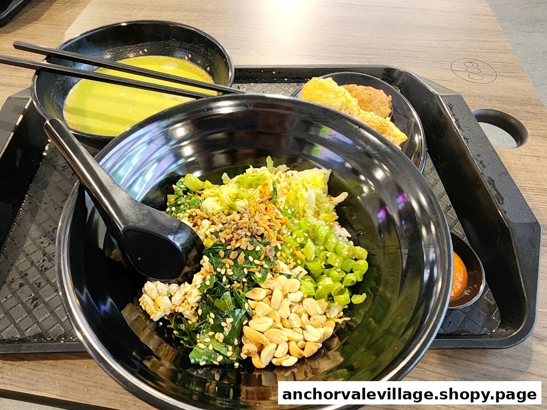 A vibrant bowl of Hakka Lei Cha (Thunder Tea Rice) with soup and fried sides on a tray.