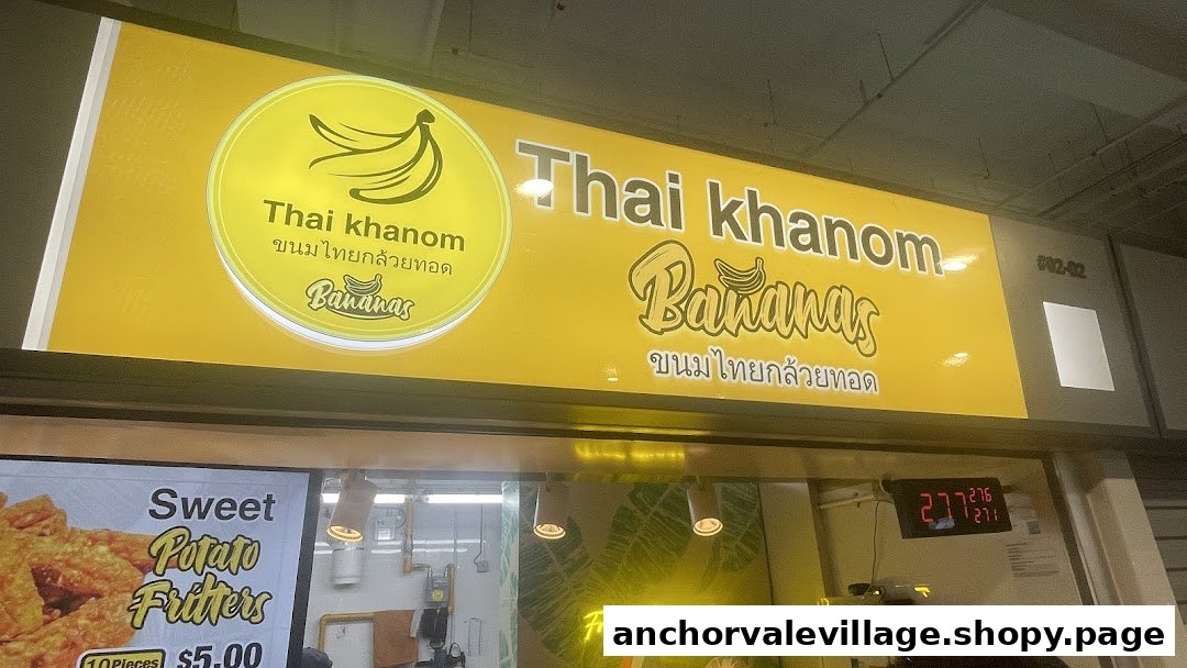 A vibrant yellow sign for 'Thai Khanom Bananas' featuring fried banana and sweet potato fritters.