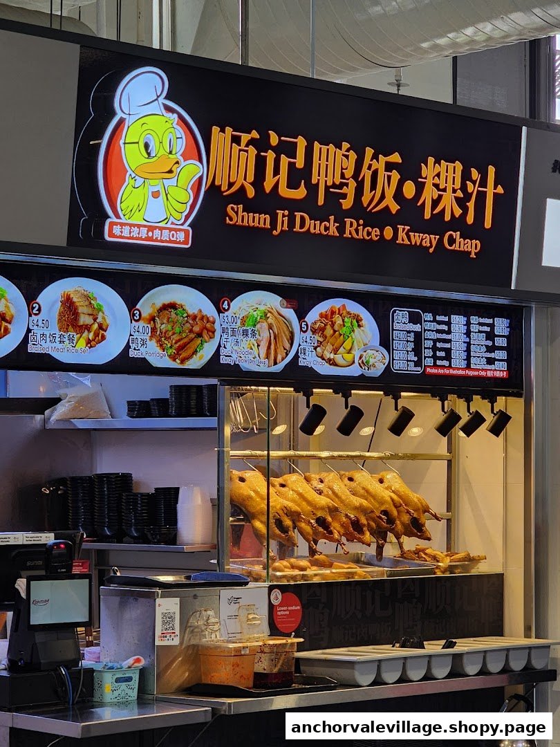 A hawker stall displaying roasted ducks and a menu board with various duck dishes.