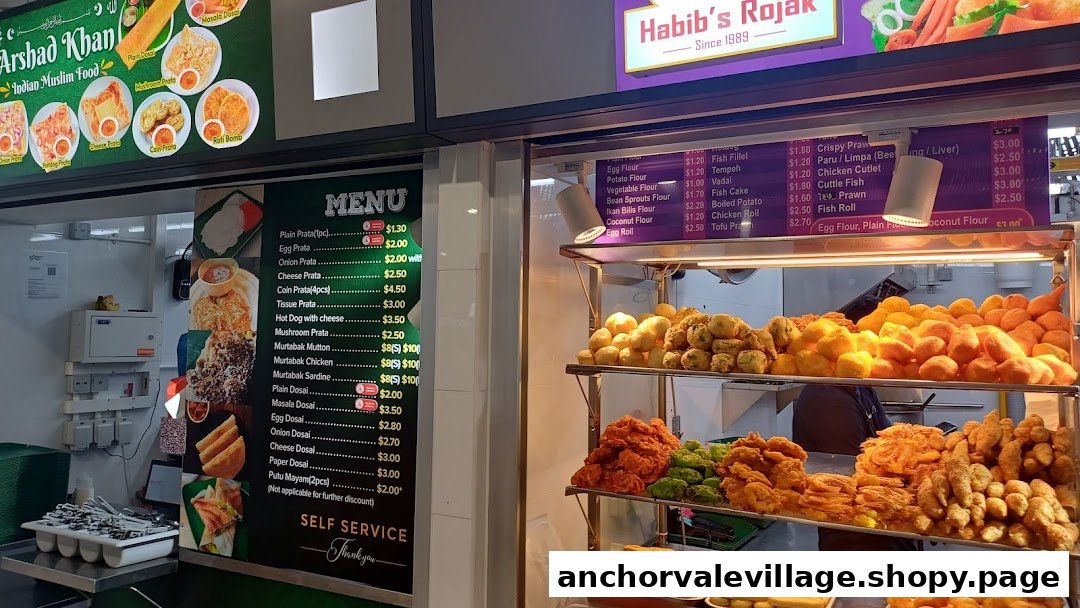 A vibrant hawker centre stall showcasing Indian Muslim food, including a variety of pratas, dosai, murtabak, and fried snacks.