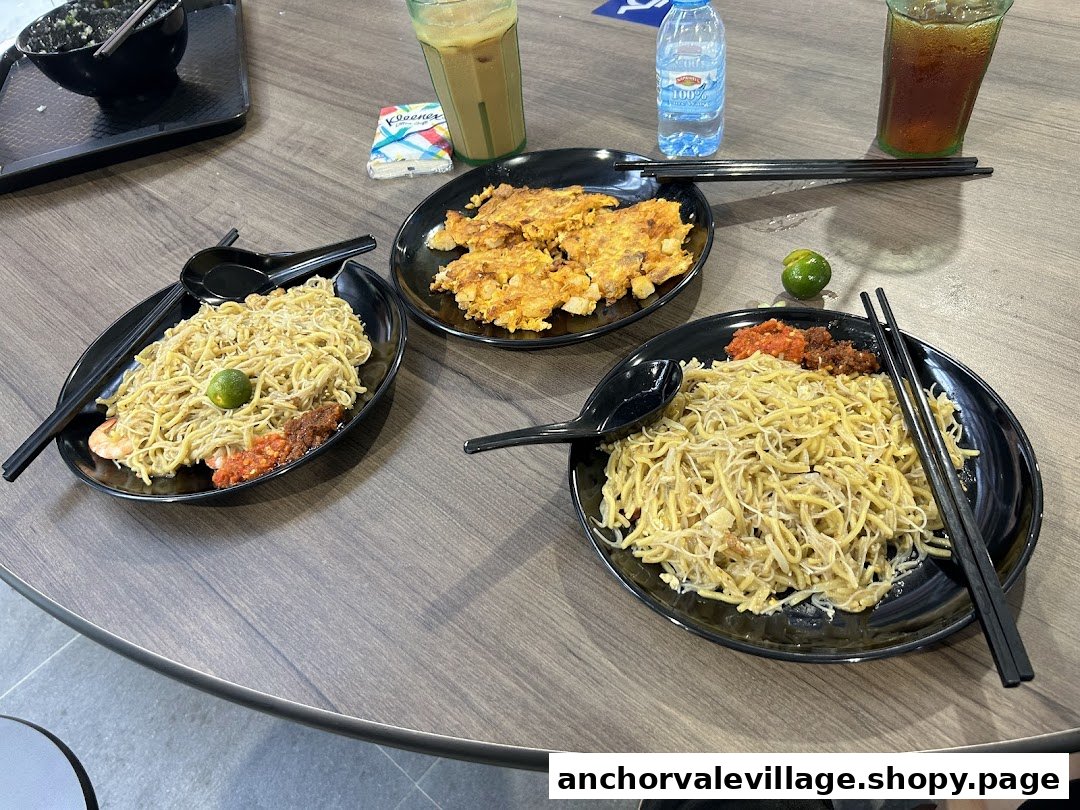 A table showcasing two plates of delicious hawker noodles, a plate of fried patties, and refreshing drinks.