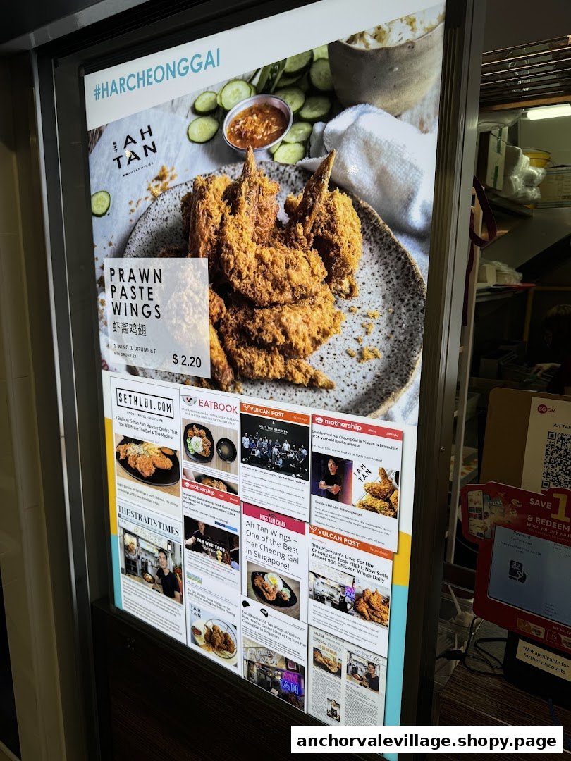 A promotional display board for Ah Tan featuring their Prawn Paste Wings and various media features.