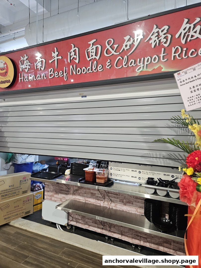 Front view of 'Hainan Beef Noodle & Claypot Rice' hawker stall with its shutter partially open.