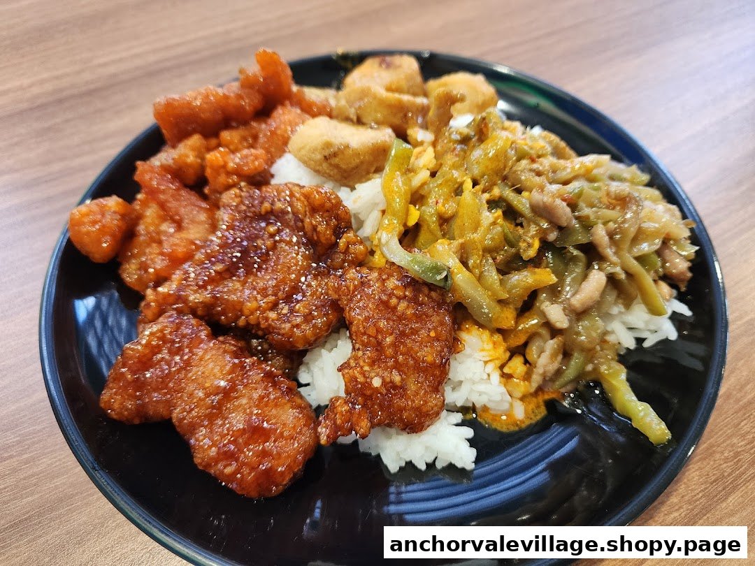 A close-up of a delicious hawker dish featuring rice, sweet and sour pork, and stir-fried vegetables.