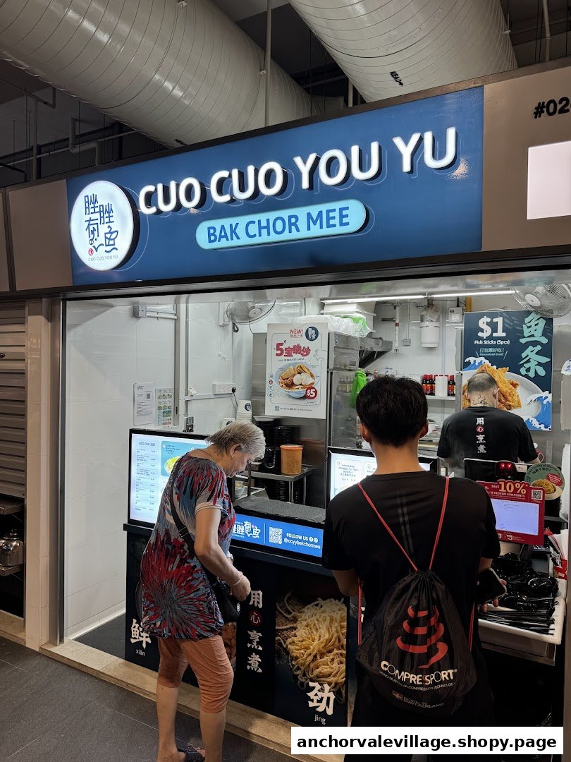 A bustling hawker stall, Cuo Cuo You Yu Bak Chor Mee, with customers ordering at the counter.