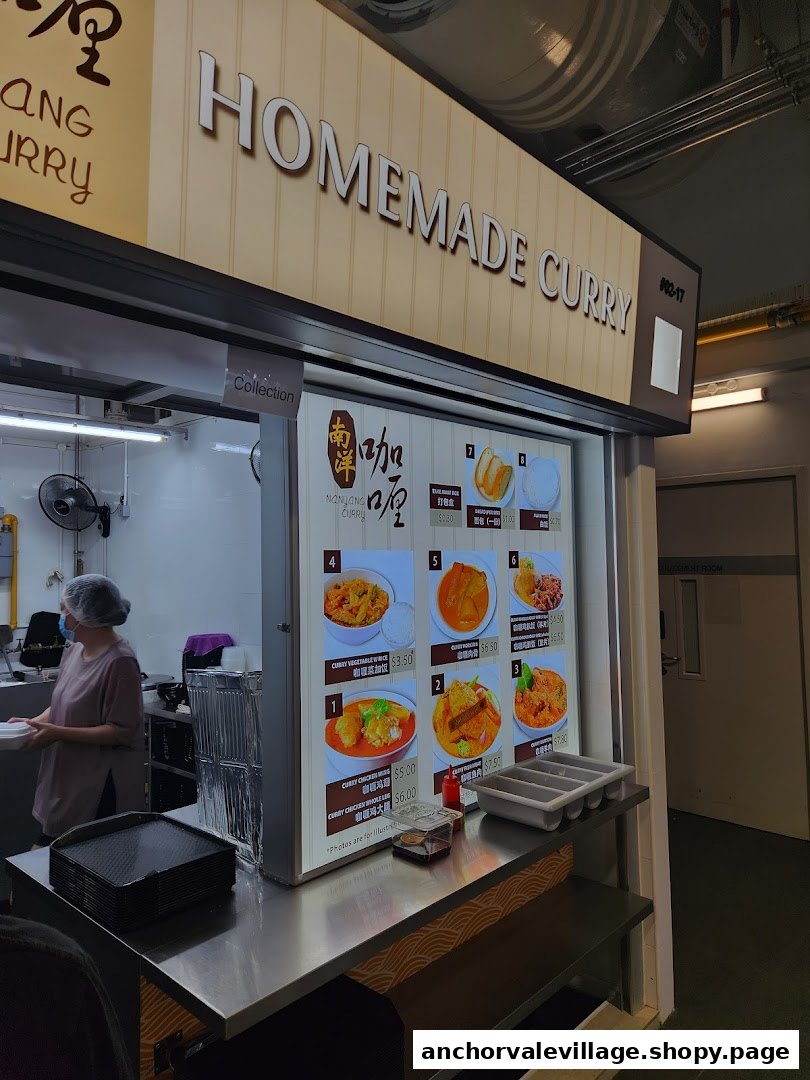 A hawker stall counter displaying a menu of homemade curry dishes with a staff member preparing orders.
