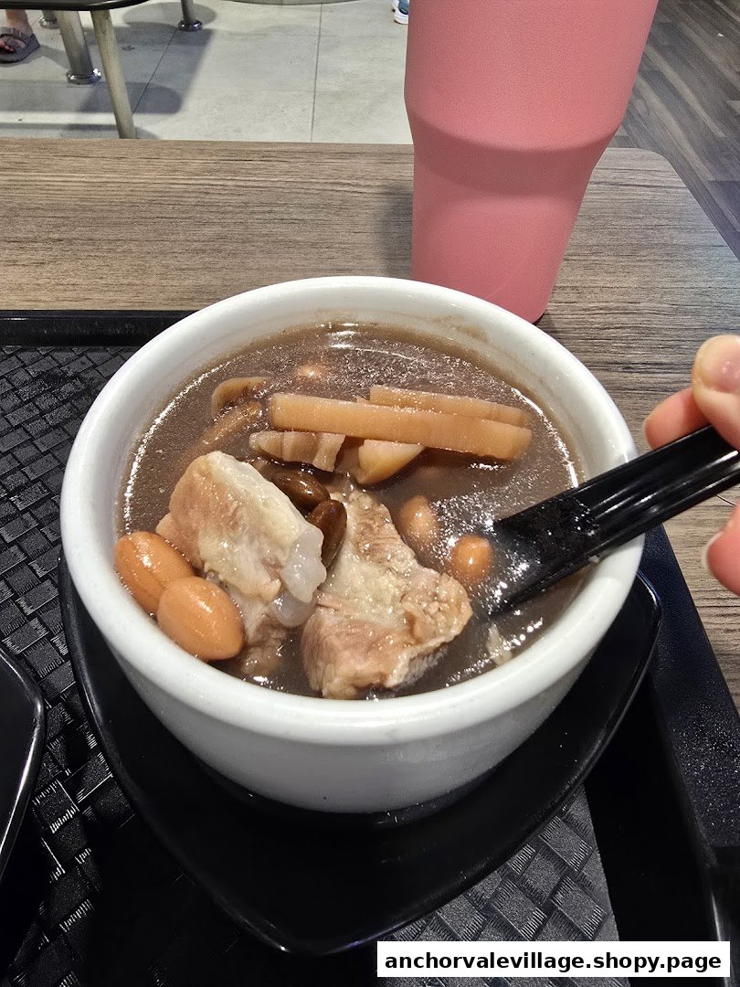A close-up of a hearty bowl of traditional Chinese soup with pork ribs, peanuts, and other ingredients.