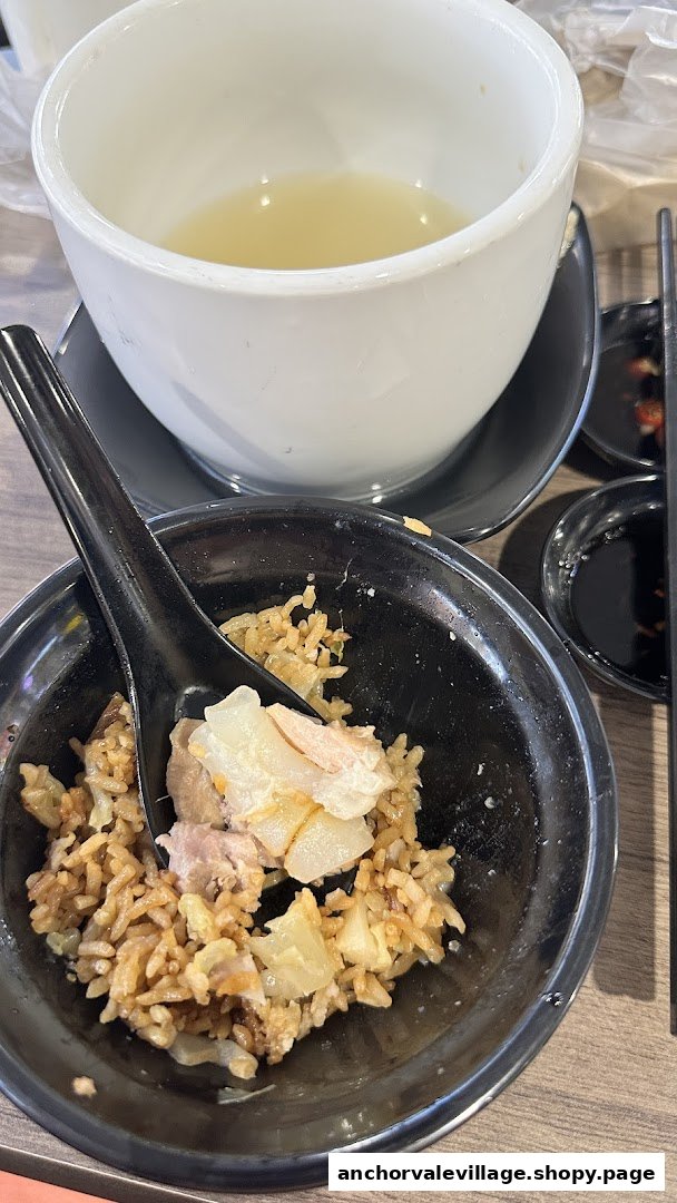 A partially eaten meal featuring a bowl of soup and a plate of rice with meat and vegetables.
