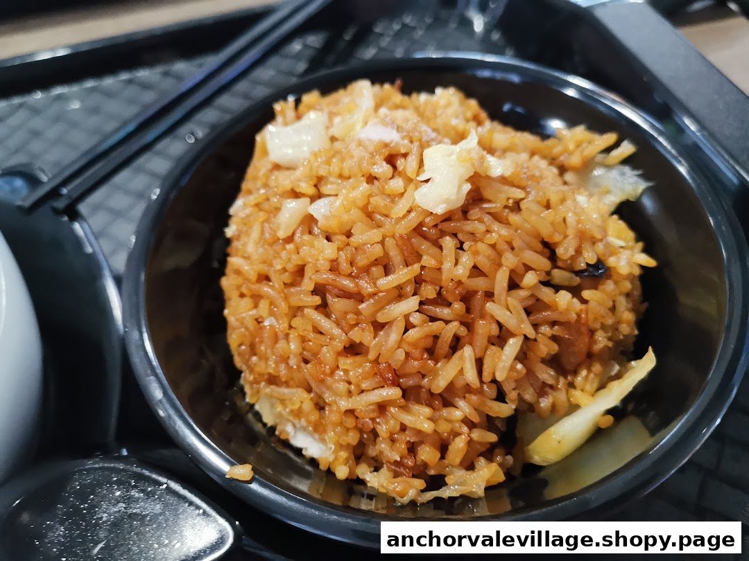 A close-up of a bowl of savory fried rice with visible ingredients.