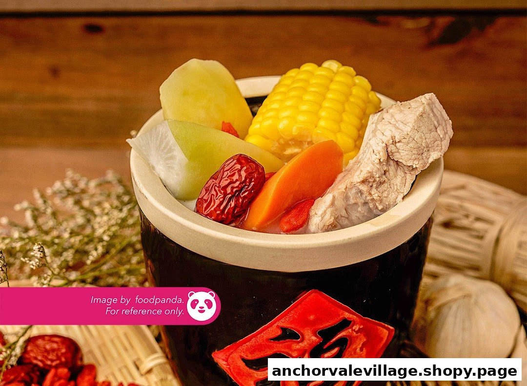 A traditional Chinese soup in a ceramic pot, featuring corn, pork, carrots, and red dates.