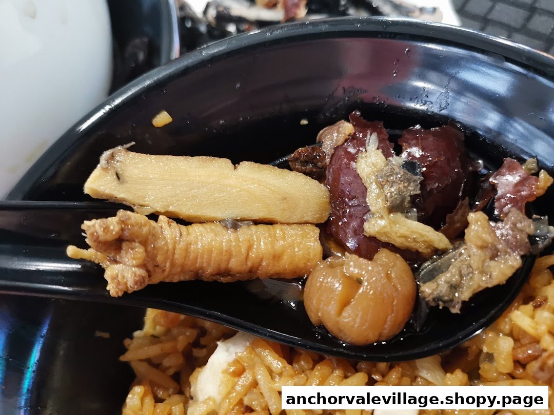 A close-up of nourishing soup ingredients, including chicken feet, herbs, and red dates, served with rice.