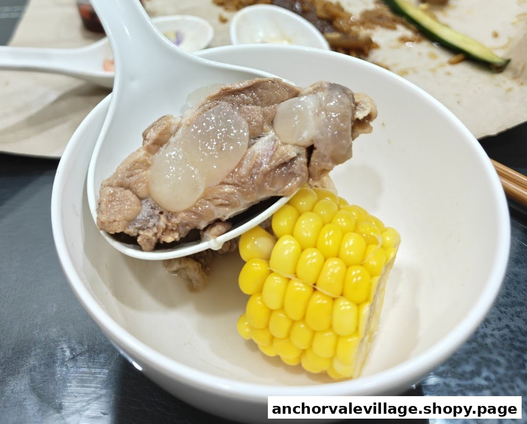 A close-up of a bowl of nourishing soup with pork ribs, snow fungus, and corn.