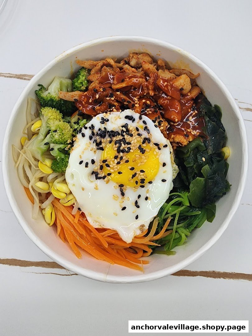 A vibrant bibimbap bowl featuring a fried egg, various vegetables, and spicy meat.