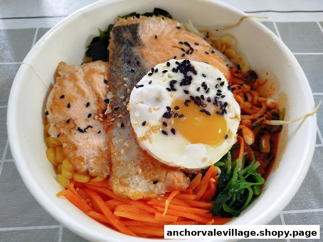 A vibrant bowl of bibimbap featuring grilled salmon, a fried egg, and fresh vegetables.