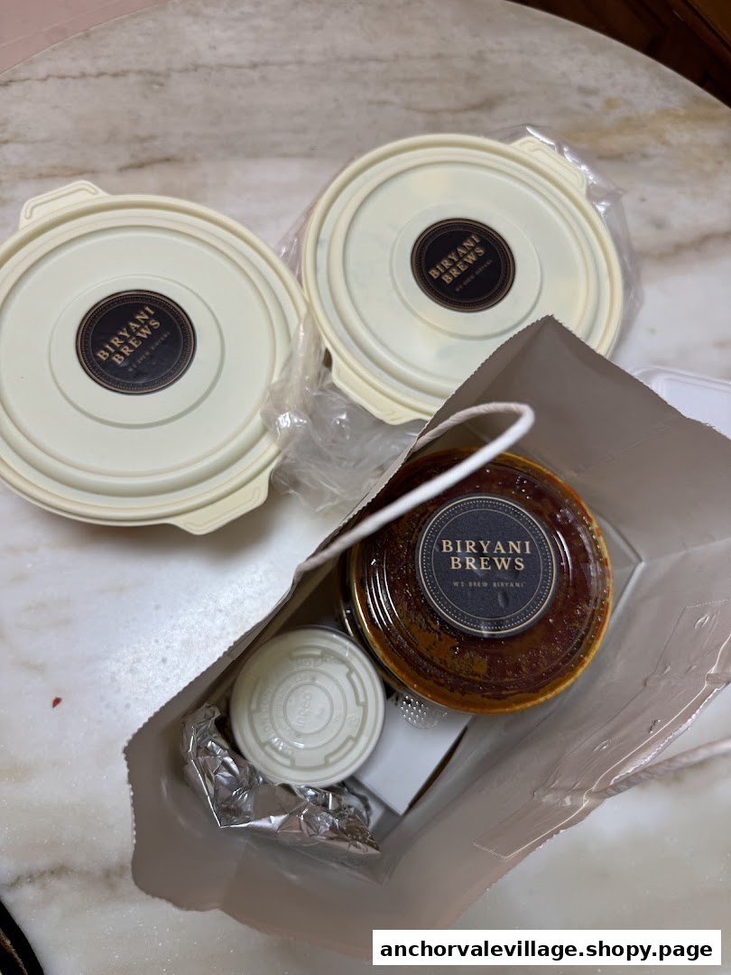 Takeout containers and a bag from Biryani Brews, featuring their branded packaging.