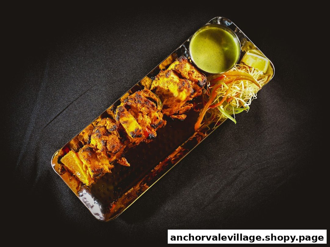 Grilled paneer or chicken tikka with fresh salad and green chutney on a dark background.