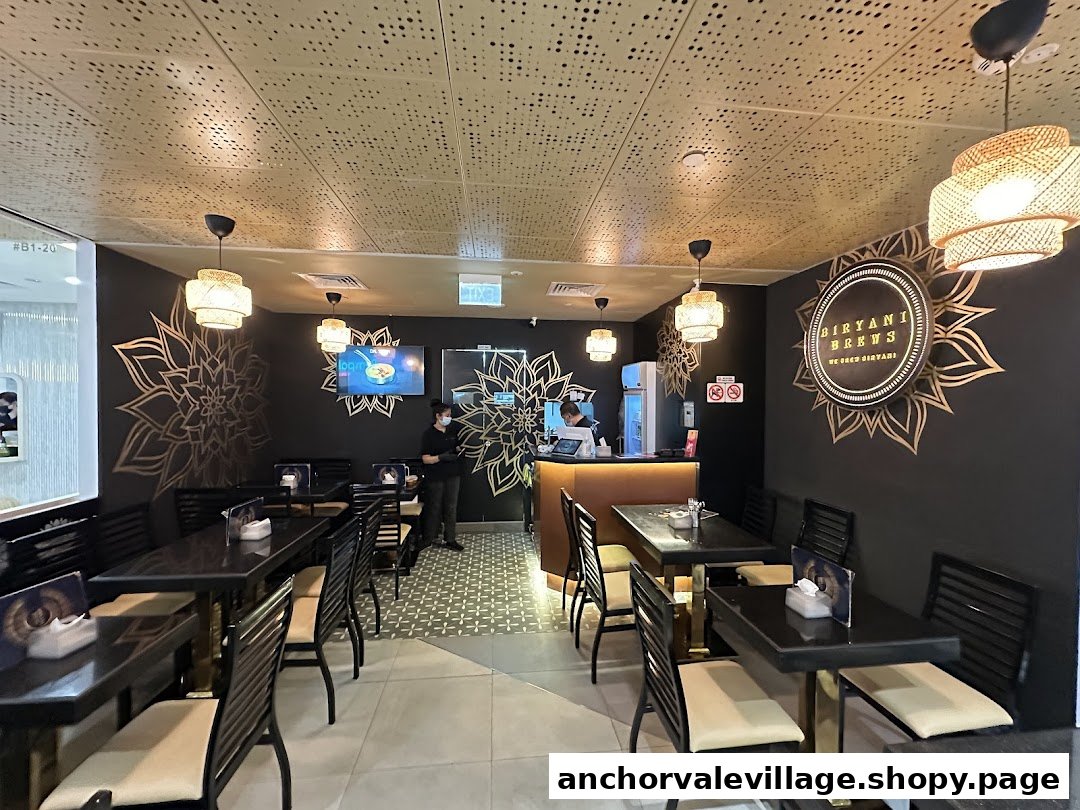 An inviting interior view of Biryani Brews, featuring dining tables, a service counter, and staff.