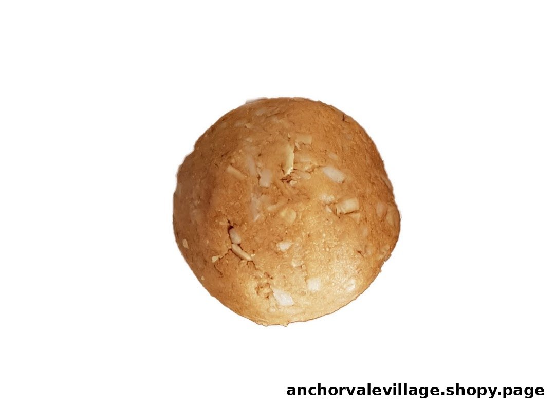 A close-up of a single, round, light brown protein ball with visible white flecks.