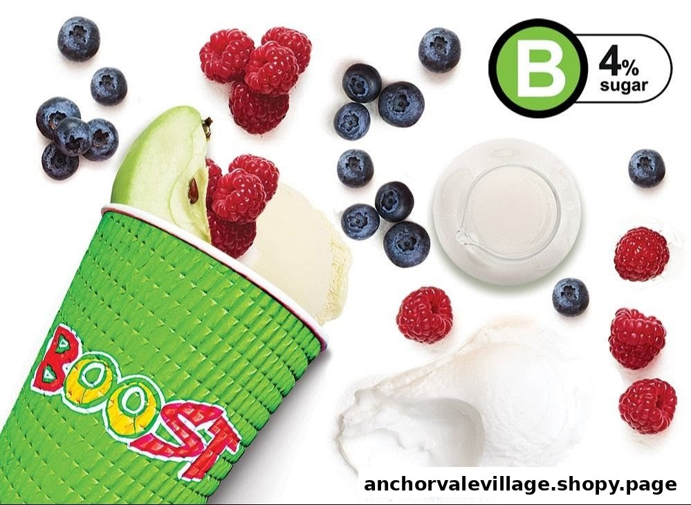 A vibrant flat lay of fresh blueberries, raspberries, apple, and creamy ingredients around a Boost Juice cup.