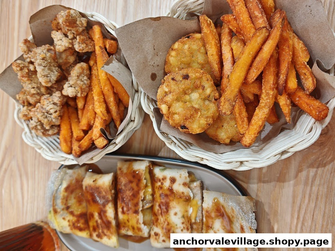 An overhead view of delicious fried chicken, sweet potato fries, hash browns, and a savory rolled dish.