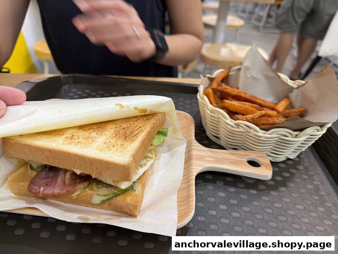 A delicious breakfast set featuring a hearty sandwich and crispy sweet potato fries.