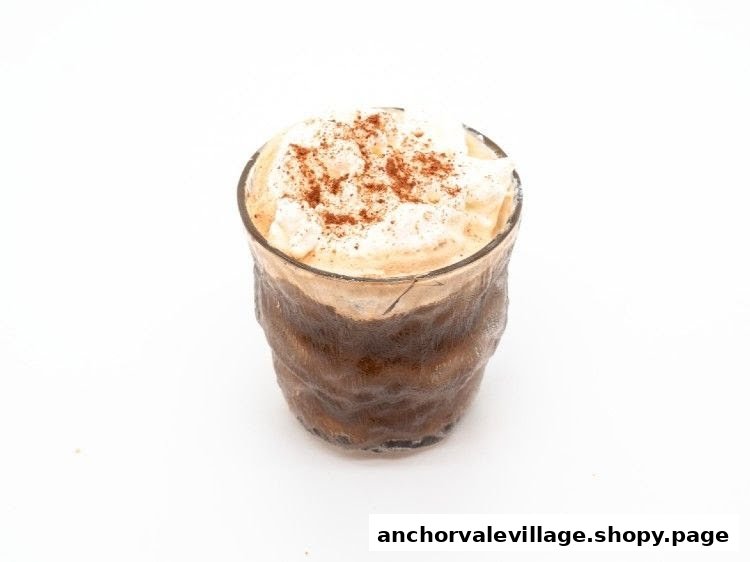 A refreshing iced beverage topped with whipped cream and a sprinkle of cocoa powder.