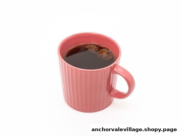 A pink ribbed mug filled with dark coffee or tea, isolated on a white background.