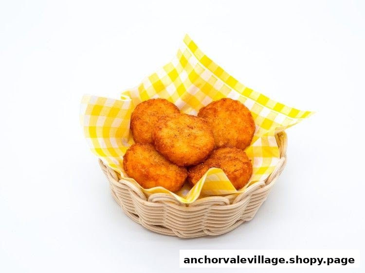 A basket of golden-brown hash browns lined with yellow checkered paper on a white background.