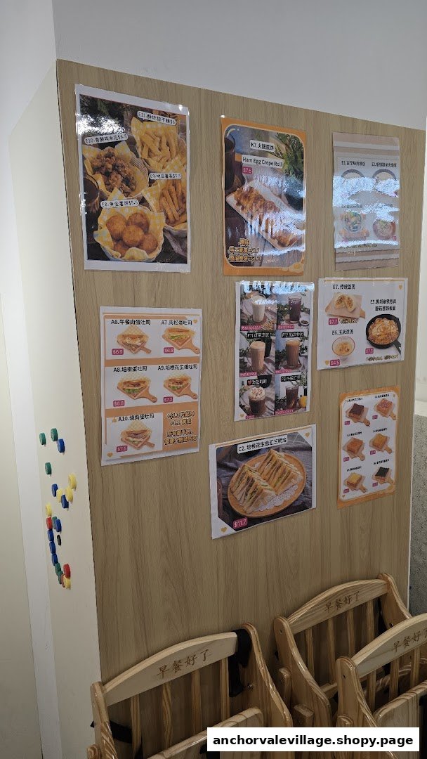 Menu boards displaying various breakfast and snack items with prices on a wooden wall, with chairs in the foreground.